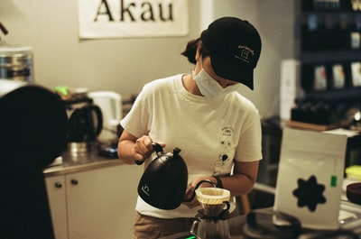 白色的水手领t恤的男子在透明玻璃杯子倒水
